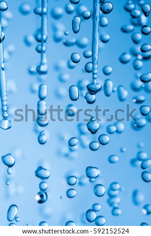 Falling water drops on blue background macro wet rain