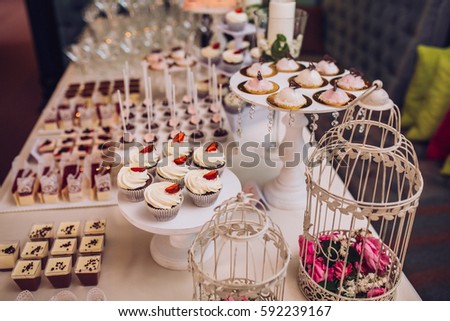 sweet bar with muffins cakes and sweets in area of wedding party