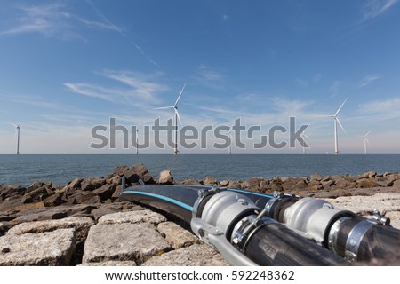 Cables in front of a group of windmills for renewable electric energy production, Westermeerwind, Noordoostpolder, Flevoland, Urk, The Netherlands Royalty-Free Stock Photo #592248362