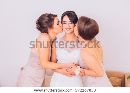 Bride and bridesmaids on the wedding day embracing each other and smiling