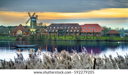 A panoramic picture of the windmill at Caldecotte Lake in Milton Keynes at sunset Royalty-Free Stock Photo #592279205