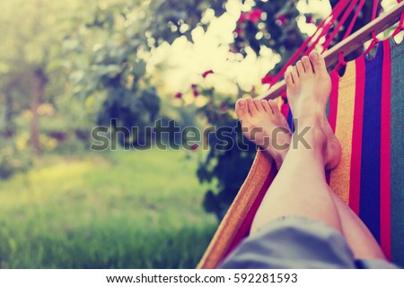 relaxing in the hammock in the summer garden Royalty-Free Stock Photo #592281593