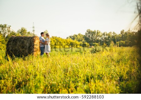 love story man and woman on the background of haystacks and sun.