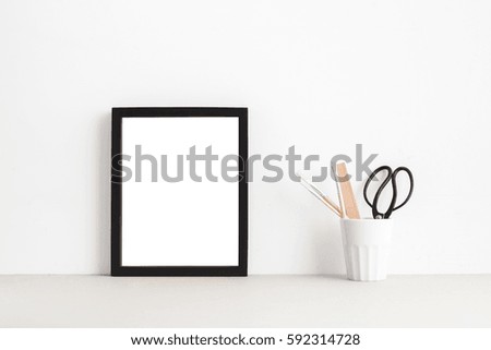 Black picture frame on table or shelf.