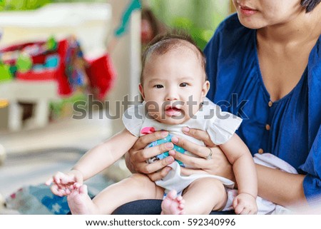 Happy infant baby girl on her mother hand