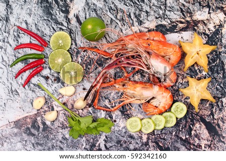 Ready streamed large fresh prawns in heart shape and spicy sour herb served on stone.