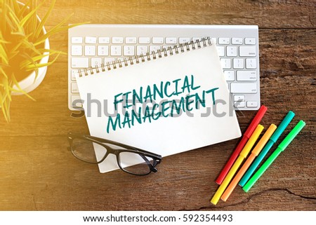 Top view notebook with keyboard concept writing FINANCIAL MANAGEMENT