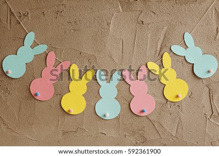 Garland with colorful paper rabbits on gray background. Concept Easter Bunny Banner.