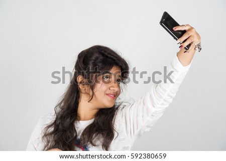 Happy young Indian girl taking a selfie.