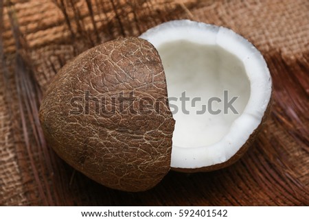 coconut cut in half in Kerala India used commonly in south Indian curry preperation and make pure and clear extra virgin coconut oil with dried on wooden table, nature background
