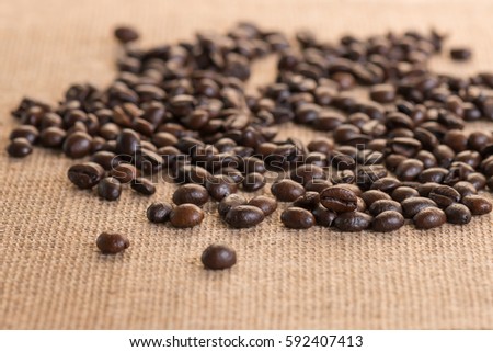 Coffee beans on sackcloth, selective focus with copy space. Roasted coffee beans for background.