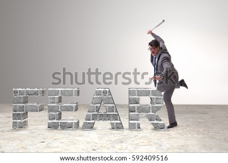 Angry man with baseball bat hitting fear word