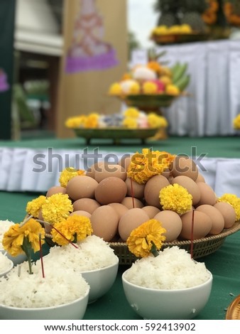 Thai traditional belief of giving respect to Buddha by arranging set of food and fruits./ Thai belief of offering food to Buddha. Royalty-Free Stock Photo #592413902