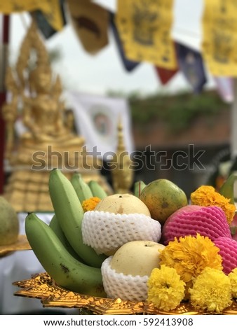 Thai traditional belief of giving respect to Buddha by arranging set of food and fruits./ Thai belief of offering food to Buddha. Royalty-Free Stock Photo #592413908