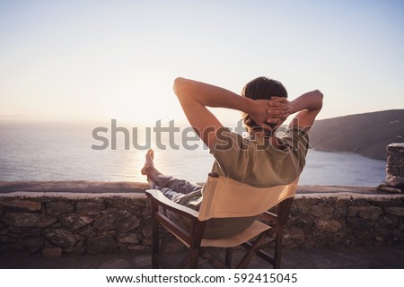 Enjoying life. Young man looking at the sea, relaxation, vacations, holidays, travel, summer fun, active lifestyle concept. Royalty-Free Stock Photo #592415045