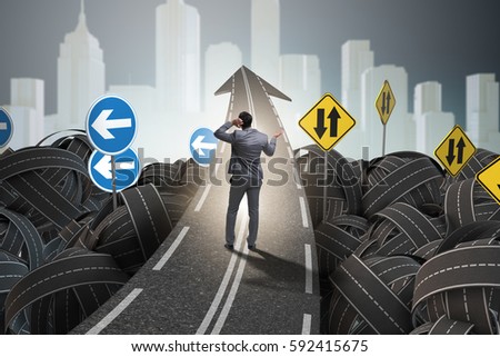 Businessman in uncertainty concept on road intersection crossroa