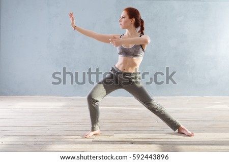 Young Woman praticing tai chi chuan in the gym. Chinese management skill Qi's energy. Royalty-Free Stock Photo #592443896