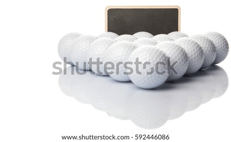 Used golf balls with a blank blackboard over white background