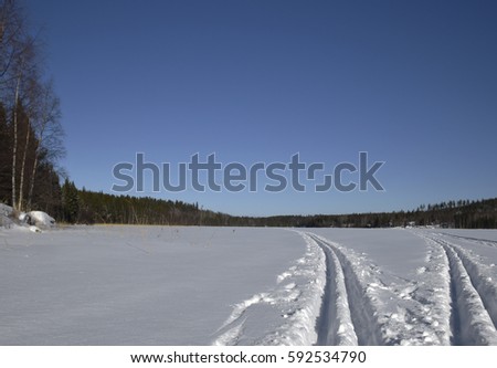 Two ski trails on a lake with blue sky in background , Picture from the Northern Sweden.