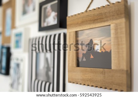family photos in different frames on a wall
