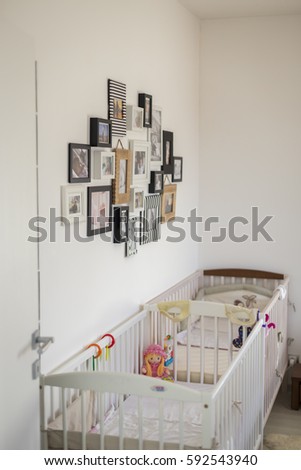 bedroom with two cots and a wall with photos in various photo frame