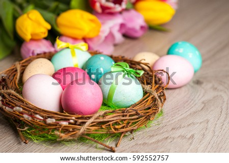Easter composition of the branches,Easter bunny, cakes, tulips colored eggs cooked for the holiday on the wooden background 
