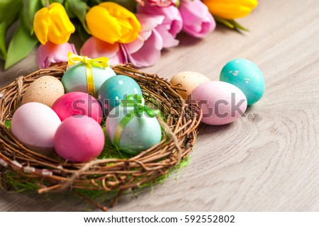Easter composition of the branches,Easter bunny, cakes, tulips colored eggs cooked for the holiday on the wooden background 