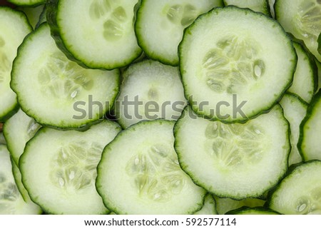 Cucumber slices as background. Green fresh cucumbers as background. Cucumber pattern texture. Vegetable food photo. Cucumis sativus, Cucurbitales.
