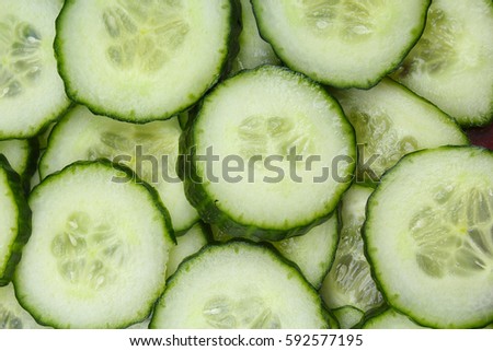 Cucumber slices as background. Green fresh cucumbers as background. Cucumber pattern texture. Vegetable food photo. Cucumis sativus, Cucurbitales.
