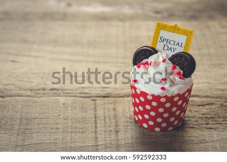 Birthday cupcake on wooden background.