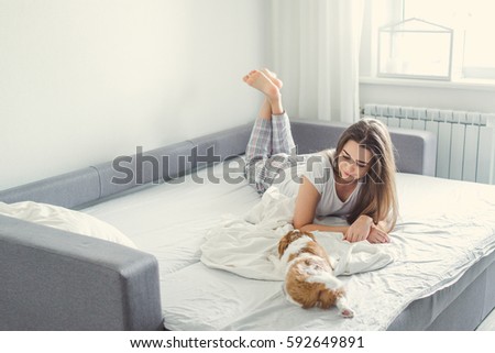 The girl with the puppy in bed. Royalty-Free Stock Photo #592649891