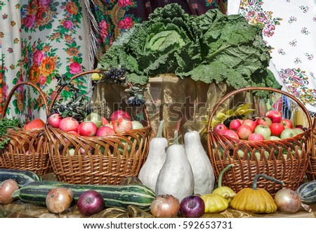 A variety of vegetables: apples in a wicker basket, pumpkin, cabbage, zucchini, onions offered for sale at the fair.