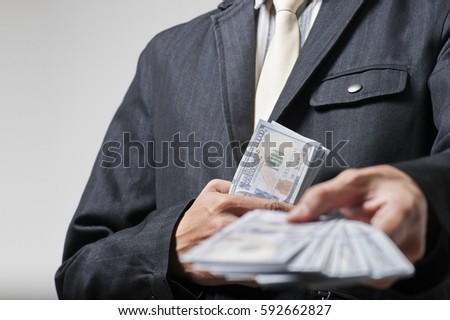 Business man giving bank notes to another person