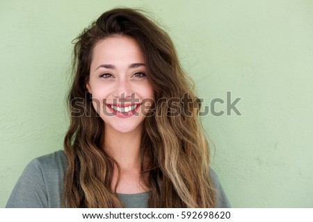 Close up portrait of young happy woman on green background