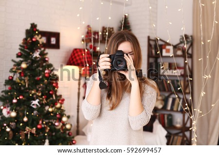 Close girl portrait with beautiful smile with dimples and curls on blond hair. Woman holds camera lady photographer. Concept of happiness, new year, christmas, photographer works.