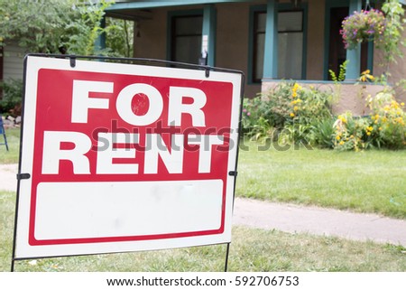 Blank for rent sign posted in the front yard of a home with porch