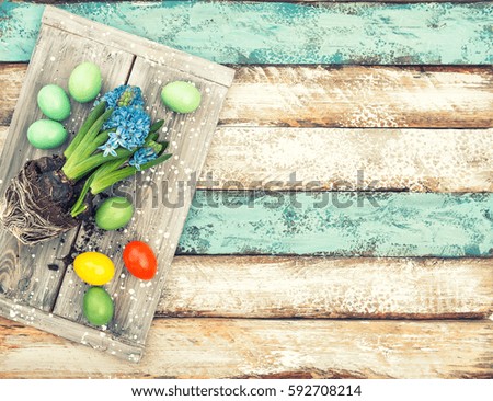 Easter eggs and hyacinth flowers on rustic wooden background. Vintage style toned picture