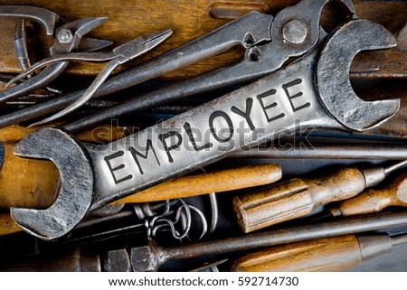 Photo of various tools and instruments with EMPLOYEE letters imprinted on a clear wrench surface
