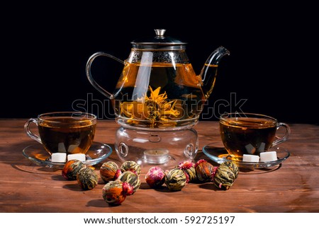 tea flower, exotic green tea on a brown board on a black background