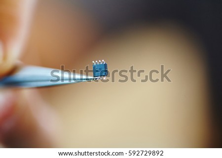 microchip with tweezers Royalty-Free Stock Photo #592729892
