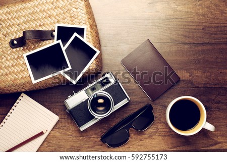 Retro camera with empty old instant paper photo album and coffee on wood background, top view (vintage style)