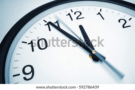 5 min before 12 o`clock on a wall clock Royalty-Free Stock Photo #592786439