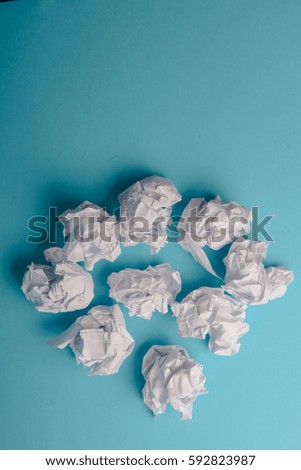 crumpled paper ball isolated on a blue background