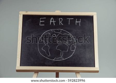 earth written on blackboard with earth symbol, background, high resolution, gray background