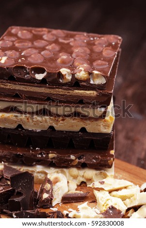 Chocolate bars on a wooden background with chocolate tower