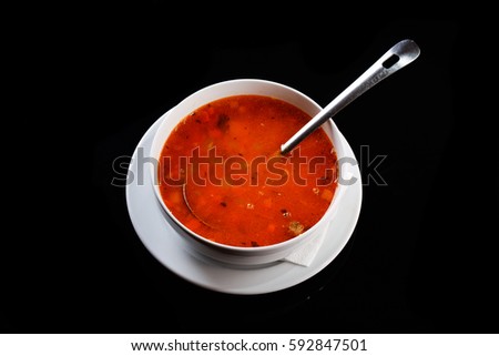 Vegetable soup in a bowl isolated on black background