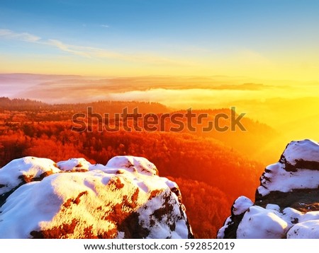 Red filter photo. Red daybreak. Misty daybreak in a beautiful hills. Peaks of hills are sticking out from foggy background, the fog is red and orange