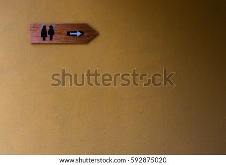 Toilet sign with brown raw concrete wall background