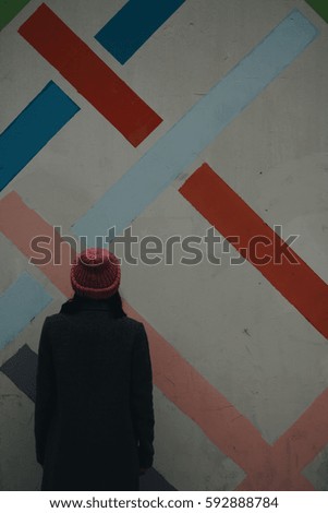Wall with color lines and girl in pink hat