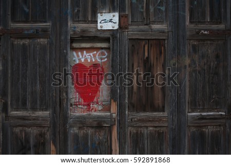 Wooden fence with broken piece, and a heart and hate sign